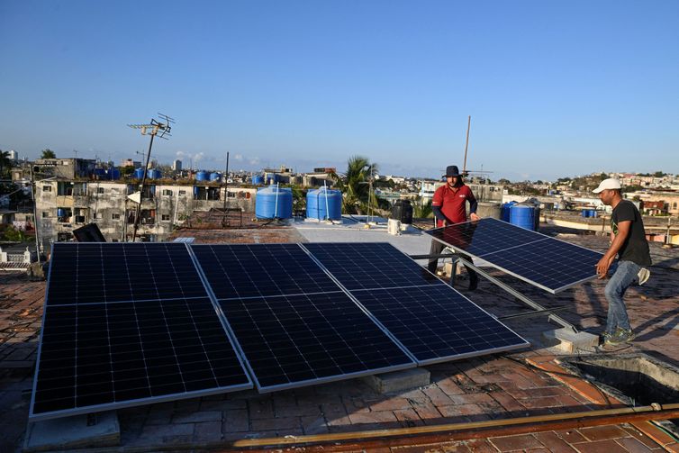 Denis Tamayo, 30, and Alejandro Guerra, 30, install a solar panel on the rooftop of a residential building as Cubans grapple with an ongoing energy crisis exacerbated by fuel shortages, Havana, Cuba February 16, 2026. REUTERS/Norlys Perez
